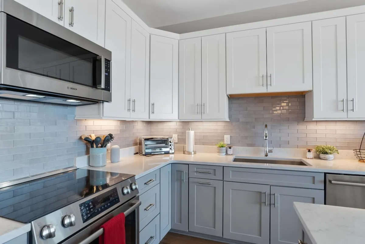 A bright, welcoming kitchen featuring stainless steel appliances, crisp white cabinetry, a modern faucet, and a stylish subway tile backsplash. The space is perfect for cooking and sharing meals with friends.